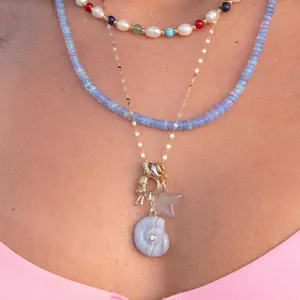 Detailed view of bohemian layered necklaces featuring colorful beads and shell pendant charms.