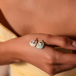 Detail shot of cute panda and penguin ceramic charms resting in tiny colorful beds