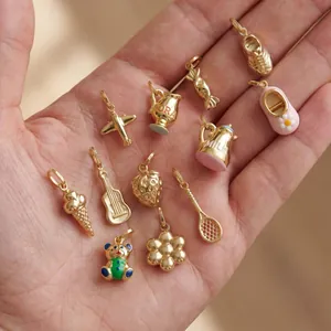 Detailed view of 18K gold-plated stainless steel charms for DIY jewelry making on a palm