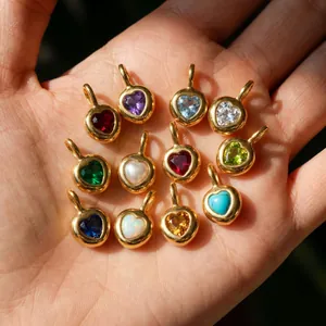 Primer plano de 12 colgantes de corazón con piedras de nacimiento en acero dorado para DIY
