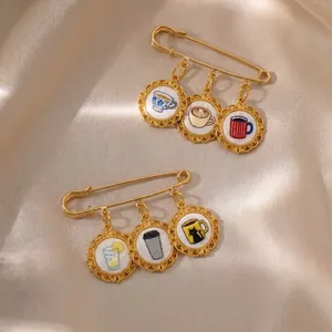 Detailweergave van 18K vergulde veiligheidsspeld broches met geborduurde koffiekopje bedeltjes