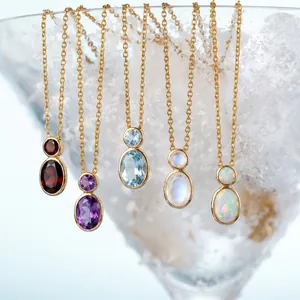 Detailed view of gold gourd necklaces with multi-color natural gemstones in a snow glass.