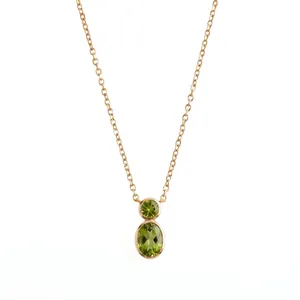 Detailed view of gold gourd necklace featuring olive green bezel-set stones.