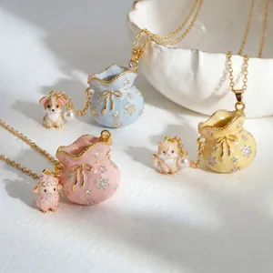 Detailed view of three enamel animal and fortune bag necklaces in pink, blue, and yellow
