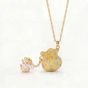 Detail of enamel lucky bag pendant with cute cat charm and pearl on gold chain