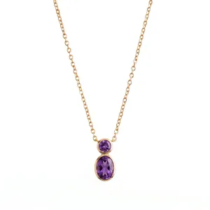 Detailed close-up of a gold necklace with two purple amethyst stones in a vertical line.