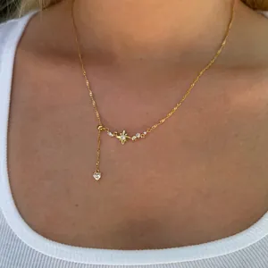 Detalle de collar chapado en oro con colgante de estrella y amuleto de corazón