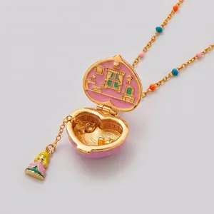 Pink and gold heart-shaped locket necklace with opening miniature room and charm
