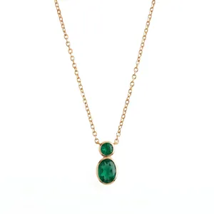 Detail of a gold bezel-set necklace with two oval green stones in a gourd shape