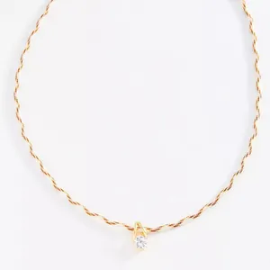 Nahaufnahme einer minimalistischen Doppelkordelkette mit kleinem klarem Zirkonia-Anhänger