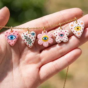 Close-up detail view of five colorful ceramic heart and flower pendants with evil eye patterns