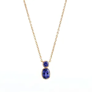 Macro view of gold bezel-set pendant with two oval and round blue natural stones