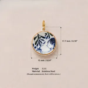 Gros plan d'un pendentif en porcelaine avec art bleu et blanc et placage en or 18 carats.
