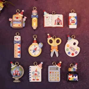 Lindos dijes de papelería con tema de circo que incluyen lápiz, libro y calculadora.