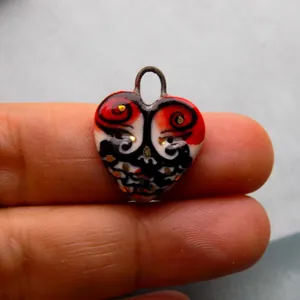 Gros plan d'un pendentif en forme de cœur en acier inoxydable aux motifs artistiques