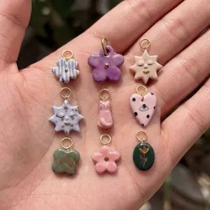 Assortment of colorful enamel DIY jewelry charms with flower heart and clover designs
