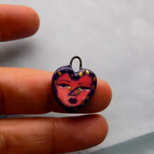 Gros plan d'un pendentif cœur en acier inoxydable avec imprimé visage unique