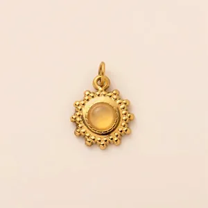 Detailed view of a gold-plated stainless steel sunburst pendant with a yellow stone center.