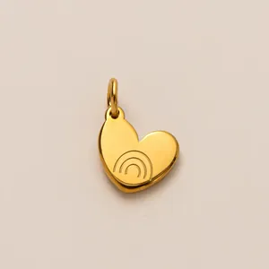 Close-up of a golden stainless steel heart-shaped pendant with rainbow engraved details