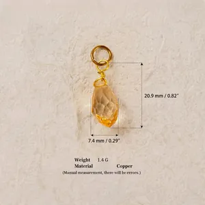 Détail d'un pendentif en cristal ambre facetté avec anneau en cuivre pour bijoux DIY.