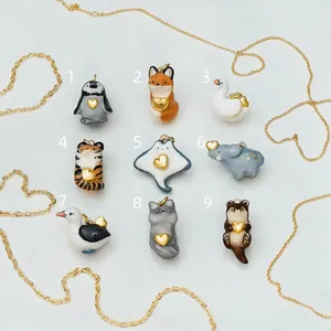 Collection of nine cute ceramic animal pendants with golden heart detail accents