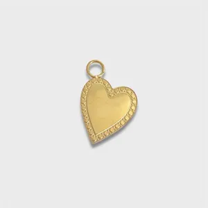 Detailed macro shot of a gold-plated stainless steel heart pendant with dotted border