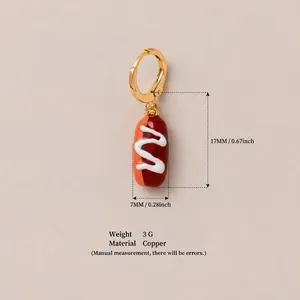 Detailansicht eines kreativen Kupferohrrings in Hot-Dog-Form mit goldenem Reifen.