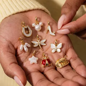 Close-up of gold-plated copper charms with pearls and mother-of-pearl inlays