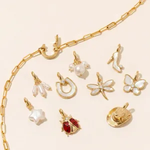 Close-up of assorted gold-plated jewelry charms featuring dragonfly and star designs