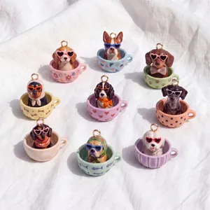Dettaglio di nove ciondoli colorati a forma di cane in tazza per creazione gioielli fai-da-te