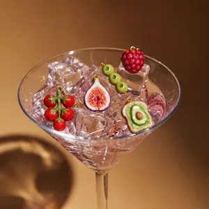 Présentation artistique de breloques fruits dans un verre à martini avec glaçons