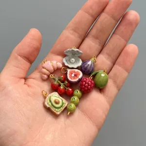 Vue détaillée de divers pendentifs alimentaires miniatures comme croissant, figue et avocat