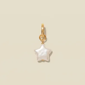 Detail view of a star-shaped pearl pendant with a minimalist gold-plated hoop bail