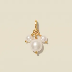 Exquisite detail of a gold-plated jewelry pendant featuring a cluster of three white pearls