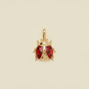 Exquisite detailed view of a gold-tone ladybug pendant with vibrant red enamel wings