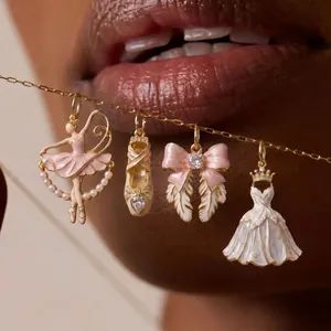 Detail view of pink ballet-themed enamel pendants featuring ballerina and tutu