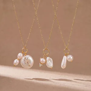Dettaglio di eleganti ciondoli in perla bianca con catena dorata e accento a fulmine.