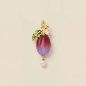 Gros plan élégant d'un pendentif en forme de fruit avec résine violette et perle