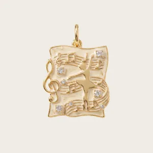 Detailed view of gold ballerina pendant with musical notes and crystal accents