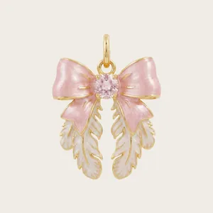 Detailed view of a pink and white enamel bow pendant with a central pink gemstone