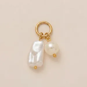 Vue détaillée de l'élégante breloque dorée ornée de perles baroques et rondes blanches
