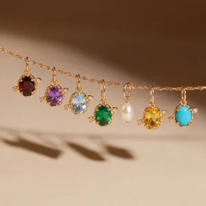 Dettaglio di una catena dorata con pendenti ovali in pietre portafortuna di vari colori.