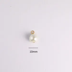 Primo piano di un ciondolo a perla bianca da 10mm con occhiello dorato per gioielli fai da te