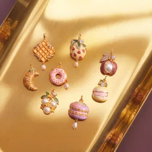 Detailed view of food-themed jewelry charms featuring waffle donut and croissant