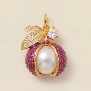 Detailed macro view of a gold-plated berry pendant with large white pearl and purple enamel