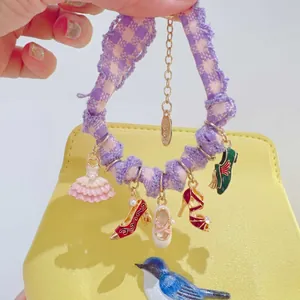 Détail du bracelet à breloques de ballet fait main avec pendentifs en émail coloré.