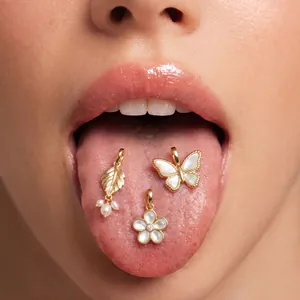 Detailed view of 18K gold plated butterfly and flower pendants on a macro background