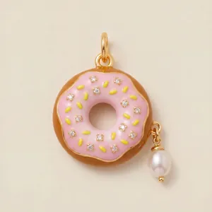 Macro detail of pink enamel donut pendant with sparkling stones and a hanging pearl