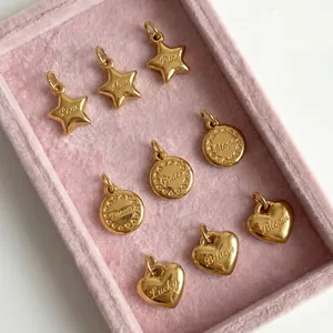 Detailed view of gold-plated stainless steel star and heart charms in a pink box.