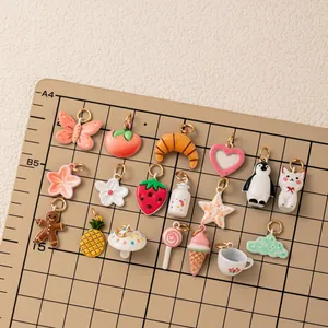 Various colorful enamel charms collection for DIY jewelry making on grid mat